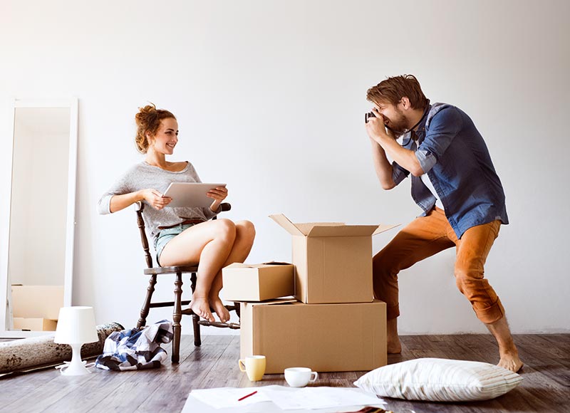 young couple moving in new house taking photos PD4QPZ5